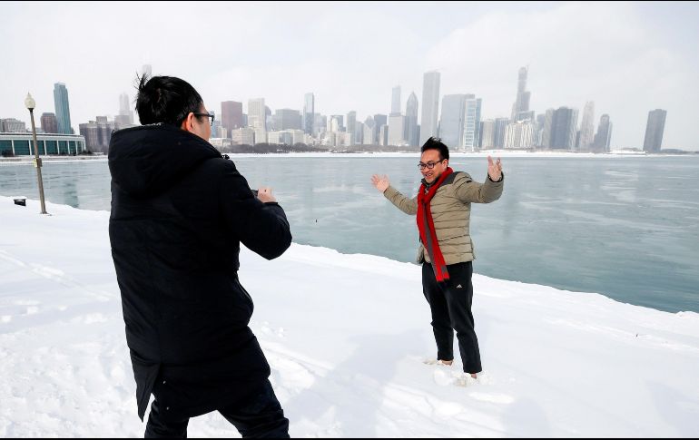 Un hombre se fotografía junto a las aguas heladas del lago Michigan en Chicago, Illinois. EFE/K. Krzaczynski