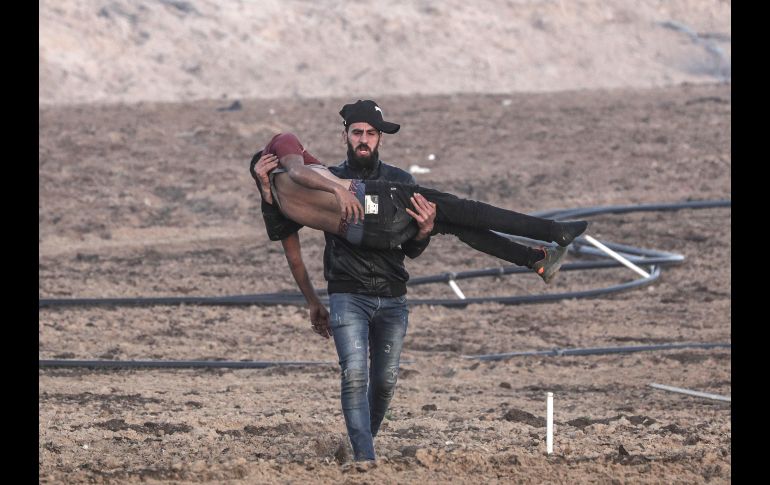 Un palestino porta en brazos a un compañero herido durante enfrentamientos entre Israel y la Franja de Gaza. La Organización para la Liberación de Palestina pidió a la ONU el despliegue de una fuerza internacional permanente en los territorios ocupados 