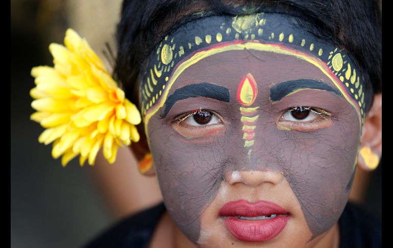 Una joven participa en un ritual hindú en Tegalalang, en la isla indonesia de Bali. Con pinturas de colores y bailes, jóvenes desfilan con el fin de ahuyentar los malos espíritus. AP/F. Lisnawati