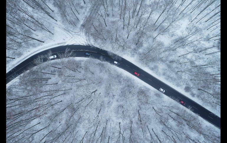 Autos pasan junto a un bosque nevado cerca de la ciudad alemana de Colonia. AFP/DPA/H. Kaiser