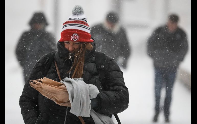 Peatones enfrentan la nieve y el viento gélido en Cincinnati, Ohio.