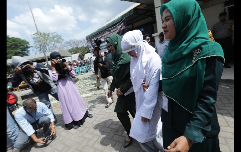 Una mujer es escoltada por dos policías de la sharia (ley islámica) al escenario antes de recibir un castigo público por mantener relaciones sexuales fuera del matrimonio en Banda Aceh, Indonesia. Aceh es la única provincia del país en que se ejecuta la ley sharia que considera a los homosexuales, bisexuales y a las relaciones fuera del matrimonio objeto de castigo. EFE/ H. Simanjuntak