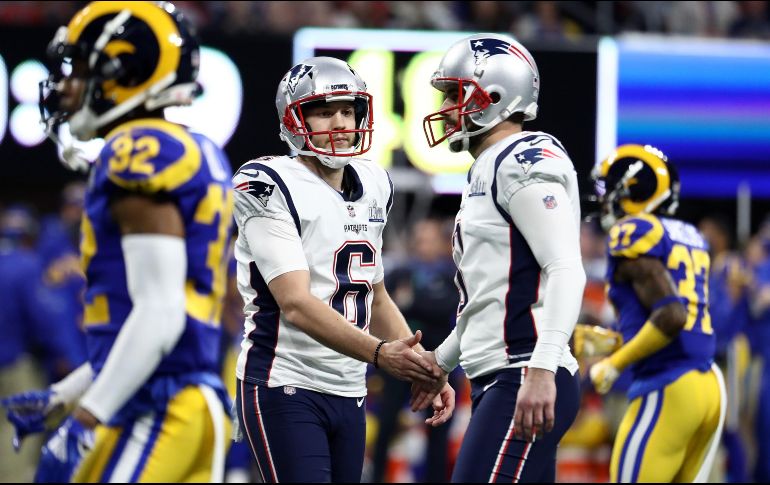 Ryan Allen felicita al pateador Stephen Gostkowski por el gol de campo que abrió el marcador en el segundo cuarto. AFP/A. BELLO