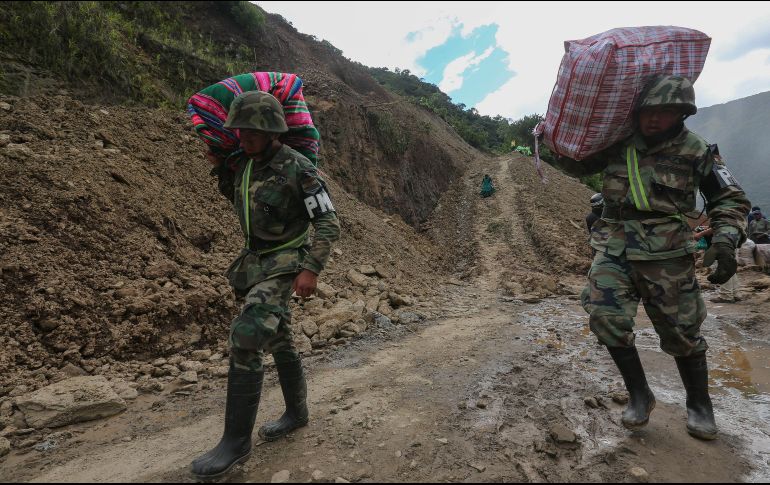 Militares bolivianos ayudan a pobladores a pasar este lunes por el deslizamiento en Puente Armas. EFE/M. Alipaz