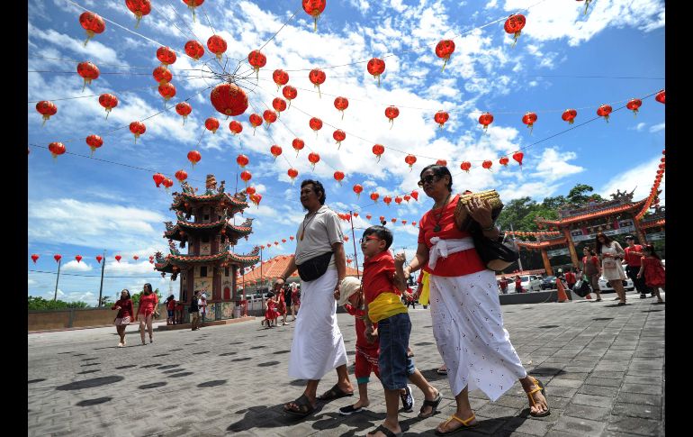 Baineses en trajes tradicionale se dirigen a un templo en Denpasar, Indonesia.