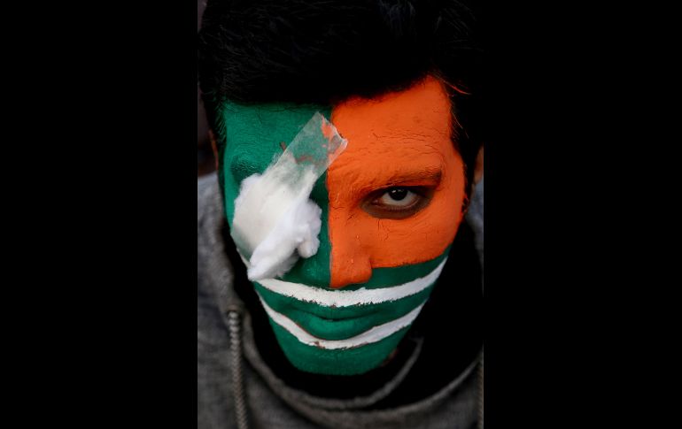 Un hombre con la cara de la bandera cachemira participa en una marcha de solidaridad con los cachemires que viven en India. Miles de personas protestaron este martes en Karachi, Pakistán, por la supuesta muerte a manos de la Policía de un activista de etnia pastún. EFE/ S. Akber