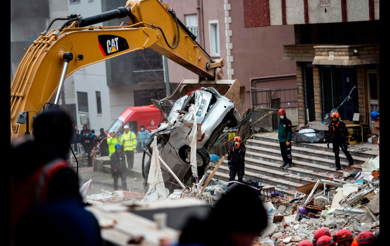 Una grúa levanta un auto mientras rescatistas continúan la búsqueda de personas entre los escombros de un edificio que colapsó ayer en Estambul, Turquía. El derrumbe provocó la muerte de al menos 10 personas. AFP/Y. Akgul