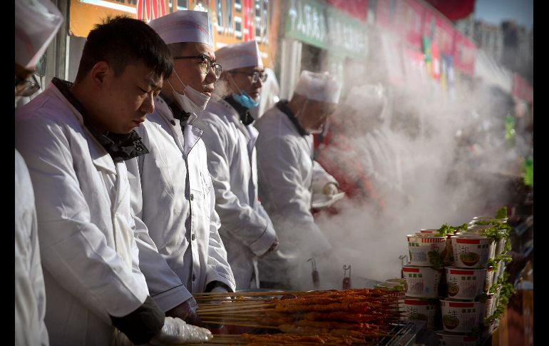 Comerciantes ofrecen alimentos en un carnaval por el Año Nuevo lunar en Pekín, China. AP/M. Schiefelbein