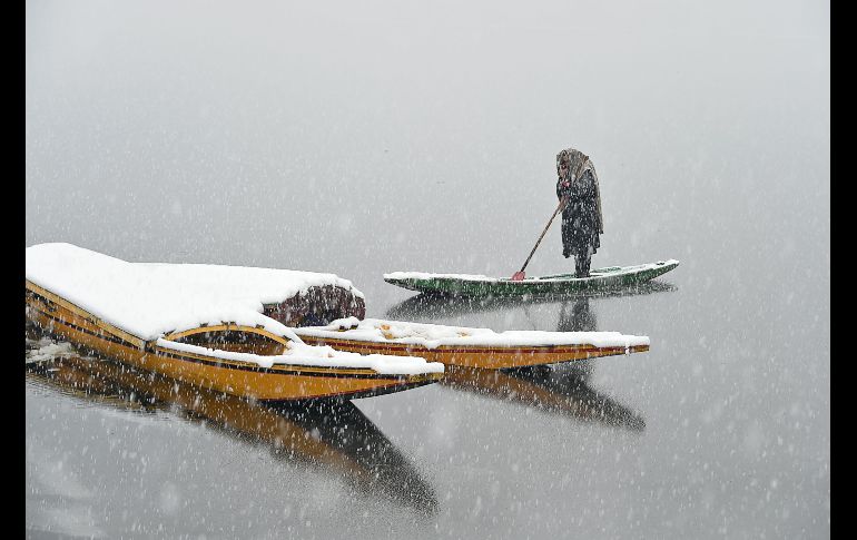 Un barquero cachemir habla por teléfono en el lago Dal en Srinagar, India. AFP/T. Mustafa