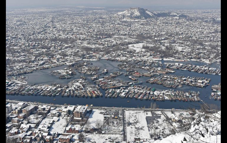 Casas y botes lucen cubiertos de nieve en Srinagar, India, luego de una fuerte nevada. AFP/T. Mustafa