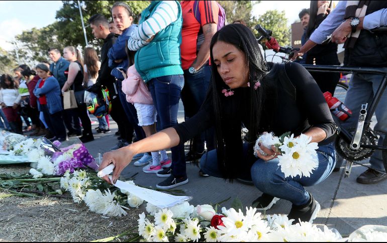 Decenas de personas llevan flores y prenden velas en honor a los policías fallecidos en el ataque a la Escuela de Cadetes de Policía General Francisco de Paula Santander. EFE/ARCHIVO