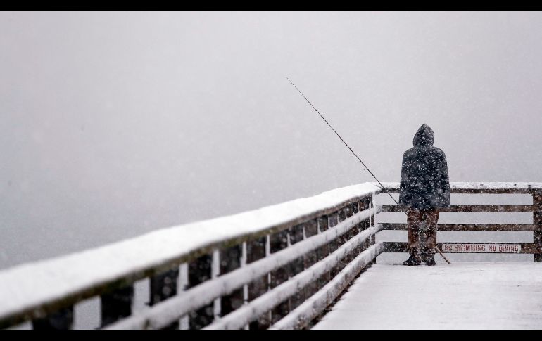 Un hombre pesca desde un embarcadero en Seattle, Estados Unidos, donde se registra una tormenta invernal. AP/E. Thompson