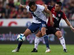 El jugador de Atlas, Osvaldo Martínez (d), disputa el balón con Jesús Zavala (i), de Puebla, durante el juego. EFE/F. Guasco