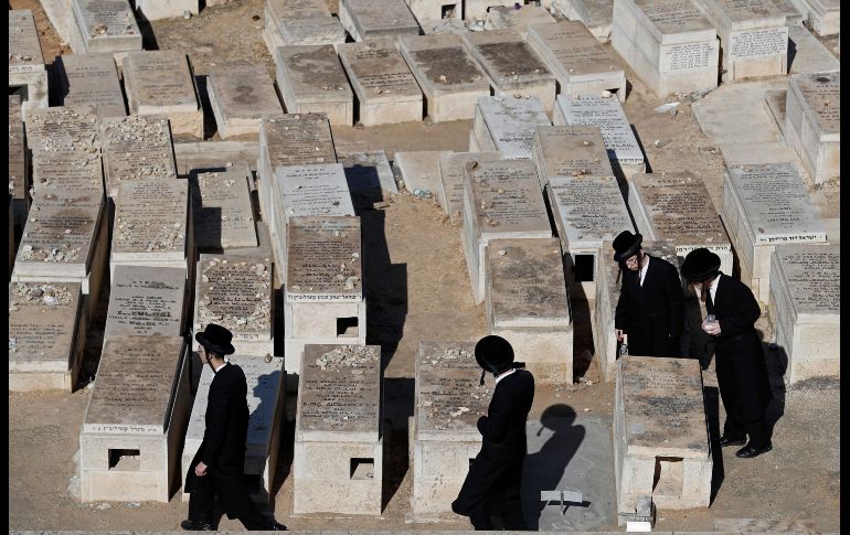 Judíos ultraortodoxos caminan entre tumbas en el Monte de los Olivos, frente a la Ciudad Vieja de Jerusalén. AFP/T. Coex