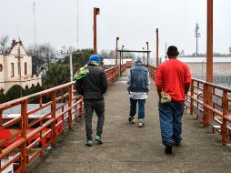 Migrantes hondureños camina por un paso peatonal en el puente Internacional 2. EFE/M. Sierra