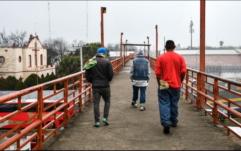 Migrantes hondureños camina por un paso peatonal en el puente Internacional 2. EFE/M. Sierra