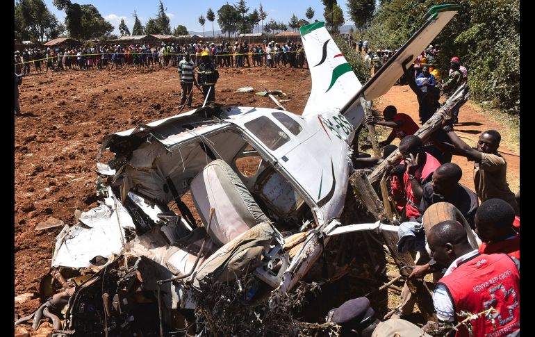 Rescatistas laboran para mover los restos de una aeronave Cessna 206 que se estrelló en Londiani, Kenia. Los cuatro pasajeros extranjeros y el piloto keniano fallecieron en el accidente. AFP/S. Mbatiah