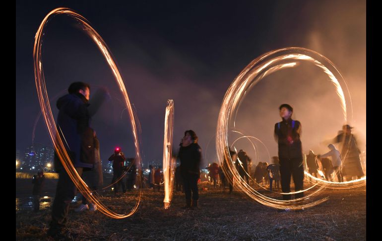 Habitantes dan vueltas a latas con carbón encendido, en un evento para celebrar la primera Luna llena del Año Nuevo lunar en Seúl, Corea del Sur. AFP/Jung Y.