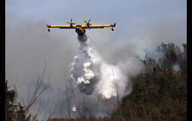 Un hidroavión participa en las tareas de extinción de un incendio declarado en los montes próximos a la localidad española de Penilla, zona donde 30 incendios se mantienen activos. EFE/P. Puente