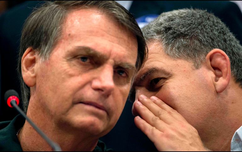 El ministro Gustavo Bebianno (d) habla con Bolsonaro (i) luego de una conferencia de prensa en Brasil. AFP/M Pimentel