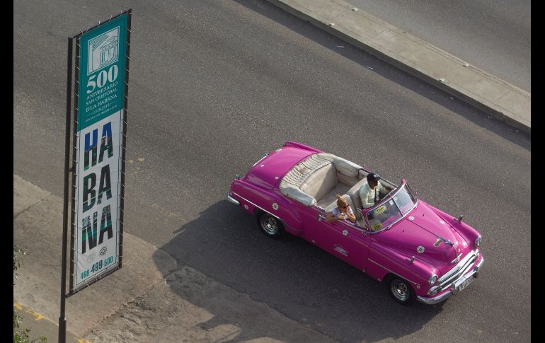 Un automóvil clásico estadounidense pasa frente a un cartel que anuncia el 500° aniversario de la ciudad, en La Habana, Cuba. EFE/Y. Zamora
