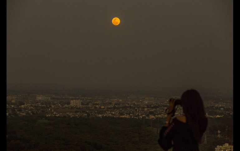Una mujer contempla la superluna sobre la ciudad india de Bhopal.