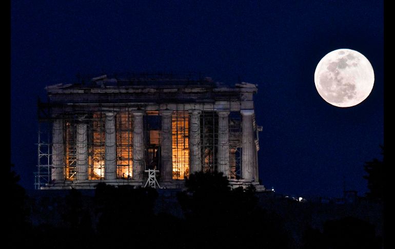 La superluna se eleva sobre el templo del Partenón en Atenas, Grecia. El fenómeno astronómico ocurre cuando la Luna llena se encuentra en su perigeo, el punto más cercano a la Tierra. AFP/L. Gouliamaki
