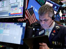 Wall Street terminó con una ligera alza ayer después de una sesión vacilante, marcada por un informe que confirmó la postura cautelosa del Banco Central de EU. AP / ARCHIVO