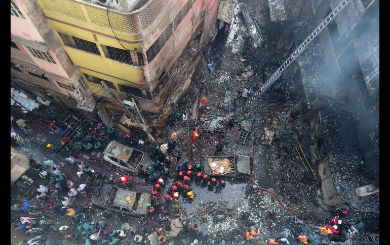Bomberos laboran en el sitio donde se registró un incendio que anoche arrasó siete edificios en Dacca, Bangladesh. Autoridades reportan la muerte de al menos 70 personas. AFP/M. Uz Zaman