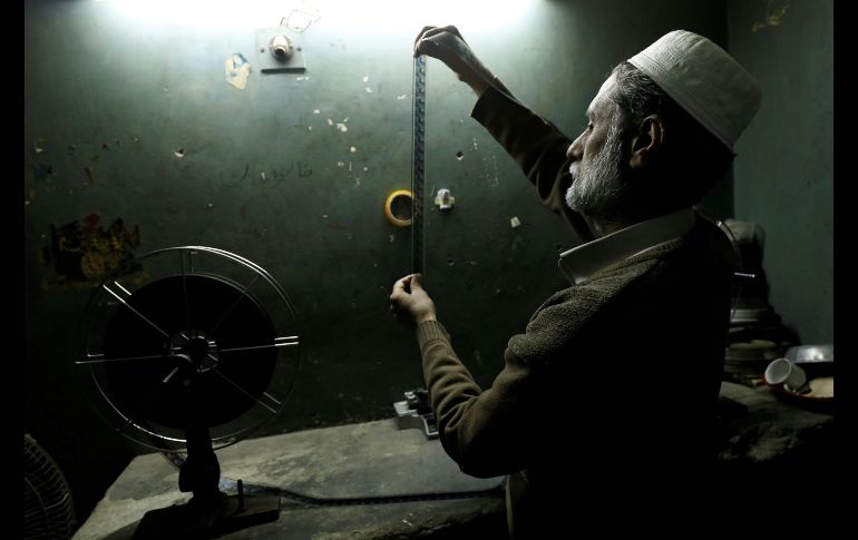 Un trabajador revisa la cinta de una película en un cine en Peshawar, Pakistán. REUTERS/F. Aziz