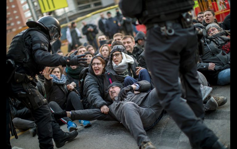 Policías quitan a manifestantes que bloquean una carretera en Barcelona, España, durante una huelga general de simpatizantes de la independencia de Calaluña. AP/E. Morenatti