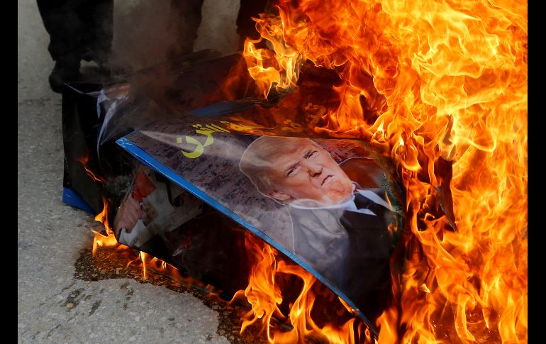 Manifestantes palestinos queman un póster con la imagen del presidente de Estados Unidos, Donald Trump, en una protesta en Hebrón, Cisjordania, para pedir la apertura de la calle Shuhada, antigua arteria comercial que Israel cerró en 1994. REUTERS/M. Qawasma