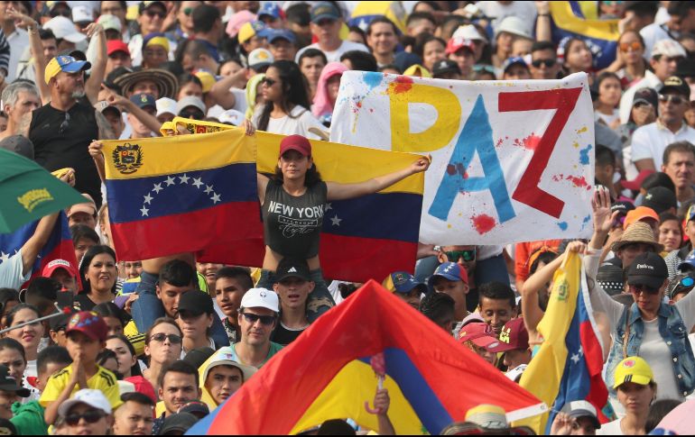 Los miles de asistentes, muchos cubriendo sus cuerpos con banderas de Venezuela, respondieron el grito de 