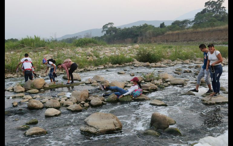 Personas cruzan el río Tachira en Palotal, Venezuela, para asistir al concierto en Colombia.