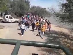 Varias mujeres corren detrás de uno de los vehículos de la Policía Federal. CAPTURA DE VIDEO