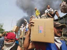 Voluntarios y manifestantes intentan salvar la ayuda humanitaria rechazada por el Gobierno venezolano. AFP