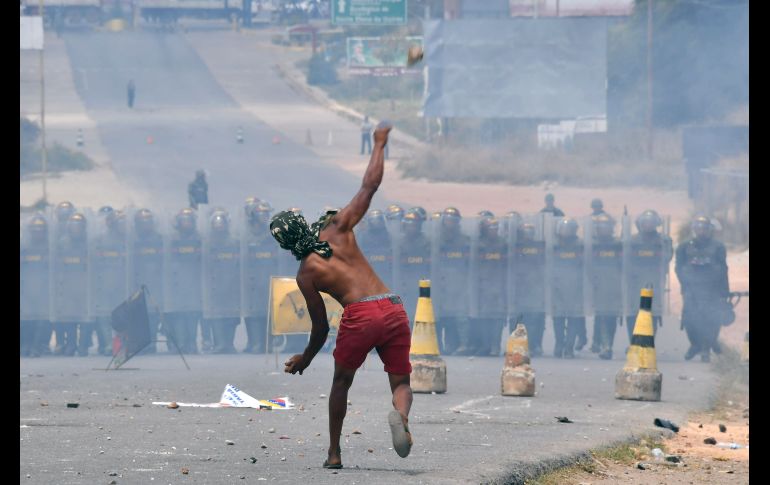Un hombre arroja piedras en Pacaraima. Los militares venezolanos respondieron con bombas lacrimógenas.