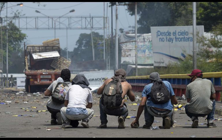 Manifestantes hoy en el puente Francisco de Paula Santander, que ayer fue escenario de violencia, cuando militares de la Guardia Nacional y policías disolvieron con andanadas de gases lacrimógenos y perdigones de goma una marcha que exigía que la ayuda cruzara la frontera.