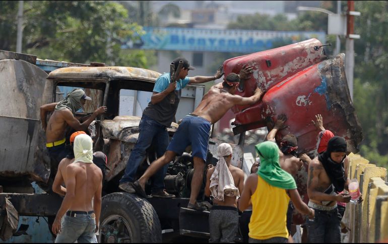 Venezolanos remueven piezas para desbloquear el puente.