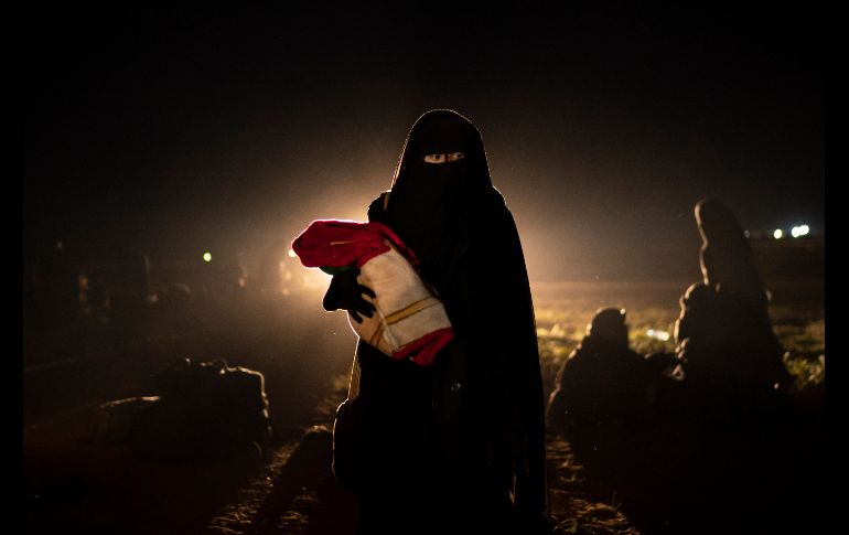 Una mujer sostiene a su bebé tras ser evacuada del último territorio bajo control del Estado Islámico en Baghouz, Siria. AP/F. Dana