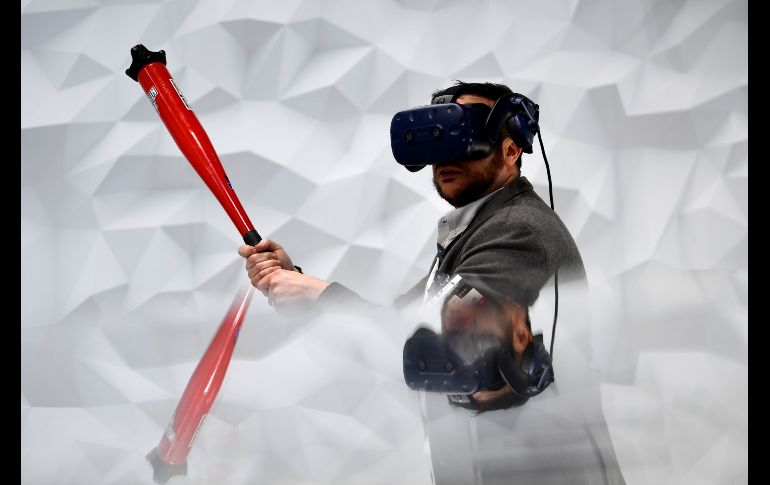 Un asistente al congreso juega con beisbol virtual con un equipo Vive Pro Eye.