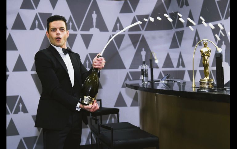Fue una noche de emociones para Rami Malek, tras recibir su Oscar a Mejor actor se cayó del escenario y luego en el festejo, fue el primero en destapar la champaña. AFP