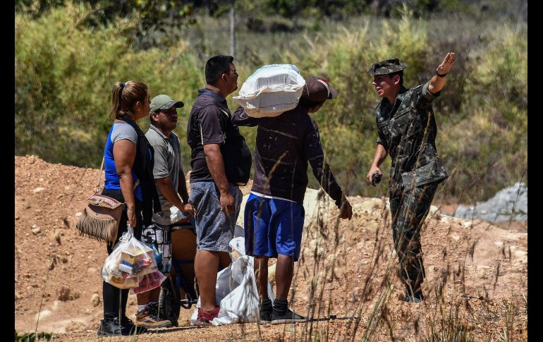 Un soldado brasileño habla con venezolanos cerca de la frontera en Pacaraima, Brasil. AFP/N. Almeida
