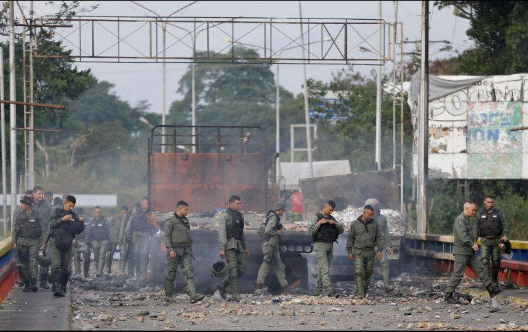 Agentes de la Guardia Nacional Bolivariana de Venezuela inspeccionan camiones incendiados durante el fin de semana durante enfrentamientos con manifestantes antigubernamentales. AP/F. Vergara