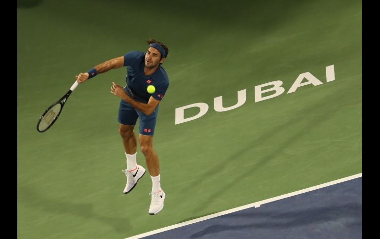El suizo Roger Federer sirve ante el húngaro Marton Fucsovics, en partido de cuartos de final del campeonato de la ATP en Dubai. AFP/K. Sahib