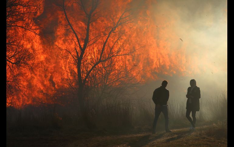 Personas miran las llamas por un incendio cerca de la población de Ivanovka, en Crimea. REUTERS/A. Pavlisha