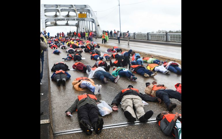 Manifestantes yacen en el puente Edmund Pettus en apoyo al derecho al voto, durante la conmemoración del 