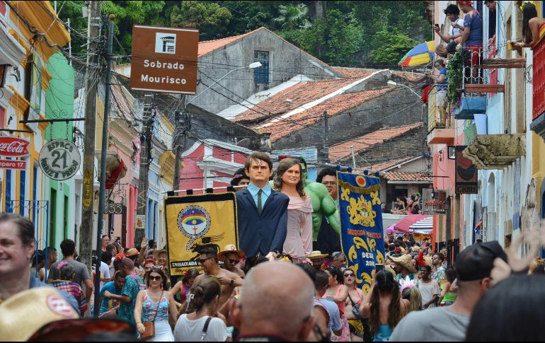 Vista de muñecos, entre el que se encuentra uno de Jair Bolsonaro (c), bailan este lunes durante el tradicional desfile de muñecos gigantes en Olinda, Brasil. EFE/N. Douglas