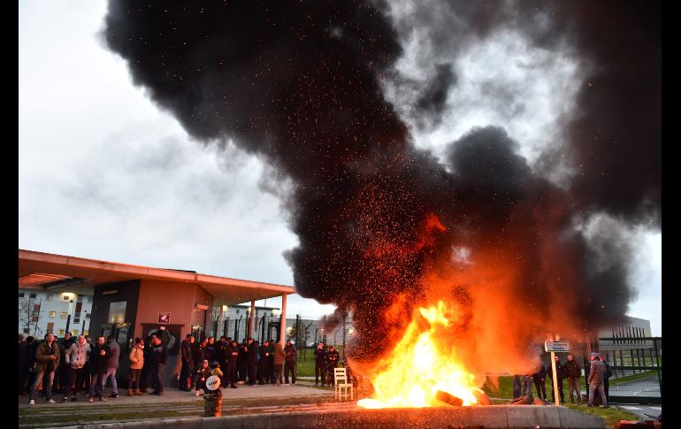 Desechos se queman mientras guardias bloquean la entrada a la prisión de Alencon, en la población francesa de Conde-sur-Sarthe, un día después de que un interno hirió a dos guardias con un cuchillo antes de ser detenido. AFP/J. Monier