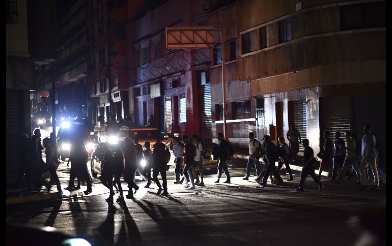 Personas caminan por una calle de Caracas la noche del jueves.